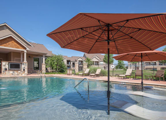 Shaded lounge seating and an outdoor TV at the cabana pool at Stonepost Ranch.