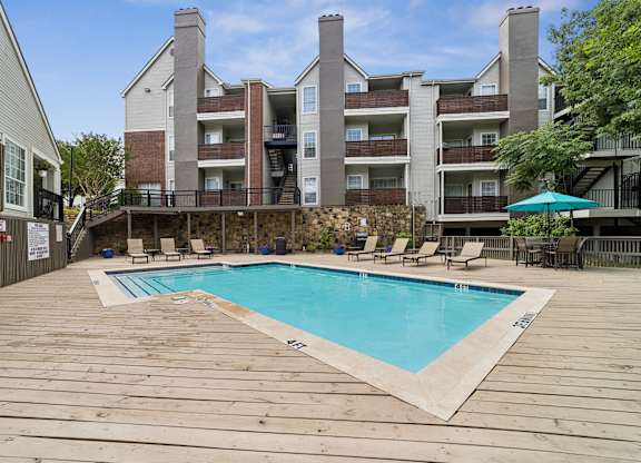 A large wooden deck with a small pool in the middle.