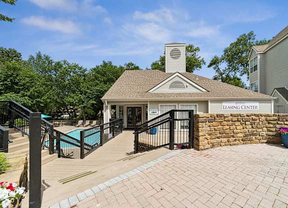 A leasing center with a pool and a brick wall.