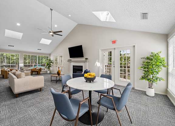 A living room with a grey carpet and a white ceiling.