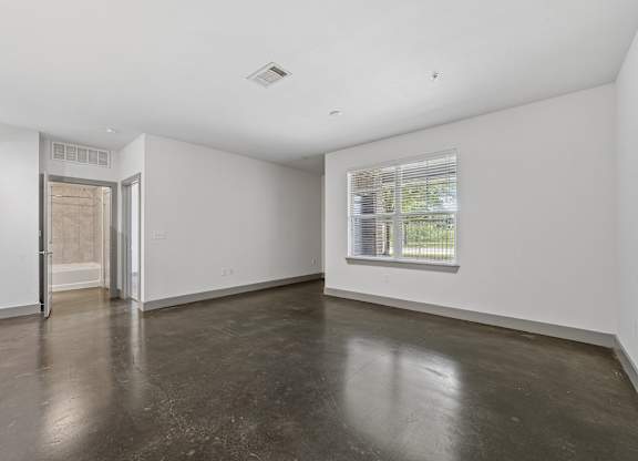 A room with a concrete floor and a window.