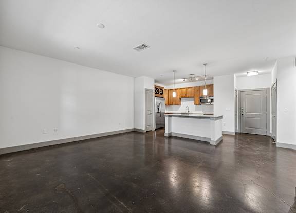 A spacious kitchen with a bar area and a sink.