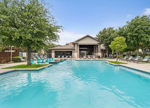 A large swimming pool with a building in the background.