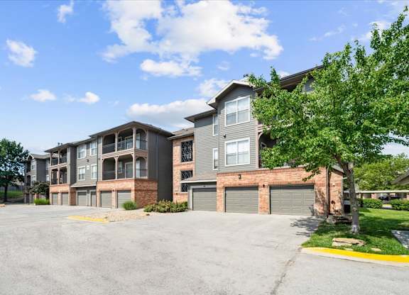 A large apartment complex with a parking lot in front.