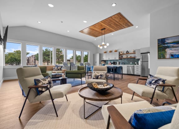 a living room with couches and chairs and a kitchen