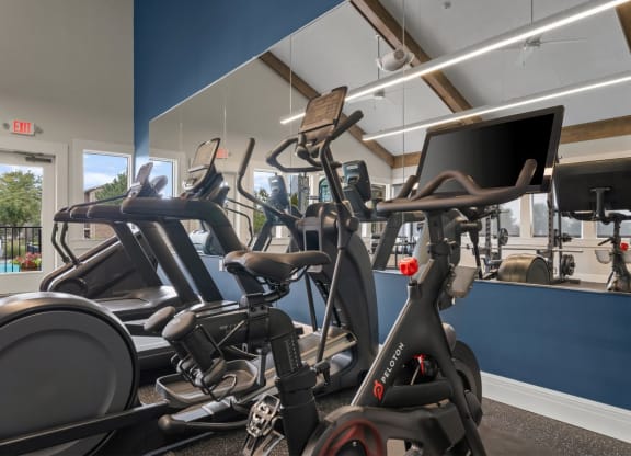 a gym with various exercise bikes and a monitor