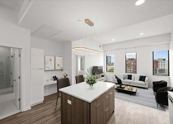 A modern kitchen with a white countertop and wooden cabinets.