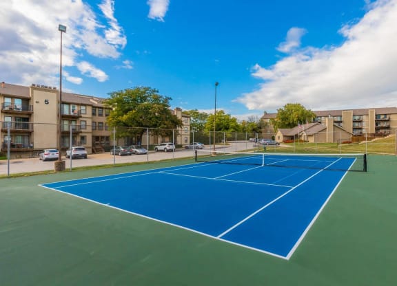 a pickleball court with apartments in the background