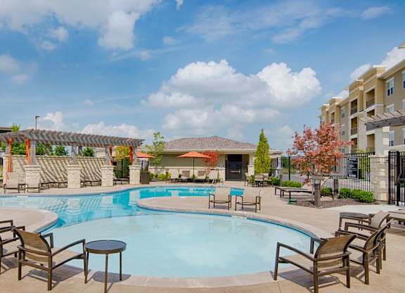 A large outdoor swimming pool surrounded by chairs and tables at Residences at Prairiefire Apartment Homes, Kansas, 66223