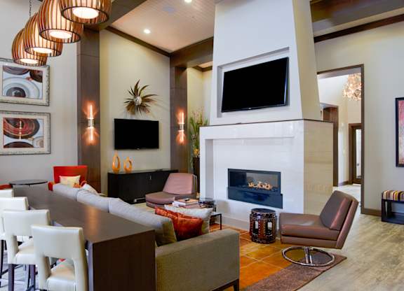 A modern living room with a fireplace and a television. at Residences at Prairiefire Apartment Homes, Kansas, 66223