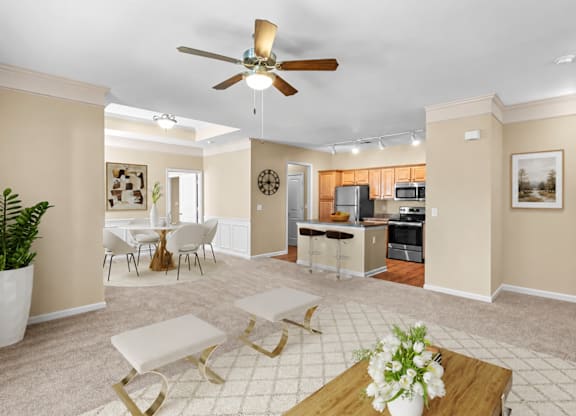A living room with a ceiling fan and a dining table with chairs.