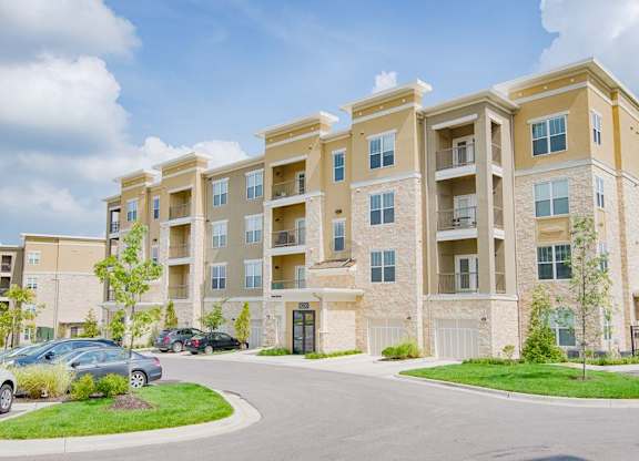 A large apartment complex with a parking lot in front. at Residences at Prairiefire Apartment Homes, Overland Park, KS, 66223