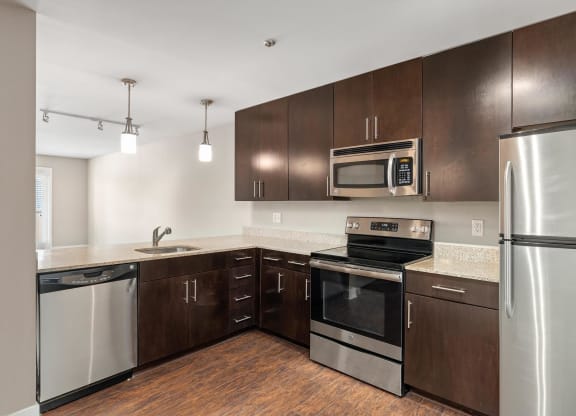 a kitchen with dark wood cabinets and stainless steel appliances
