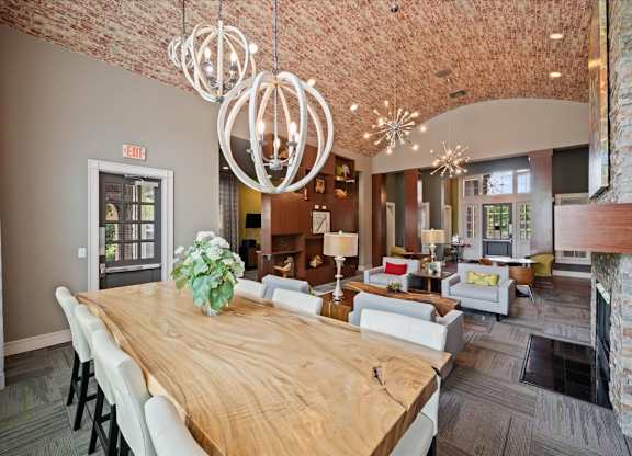 A large wooden table with chairs and a vase of flowers is the focal point of this room.