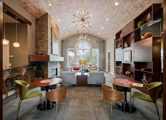 A large room with a fireplace and a dining table with chairs.