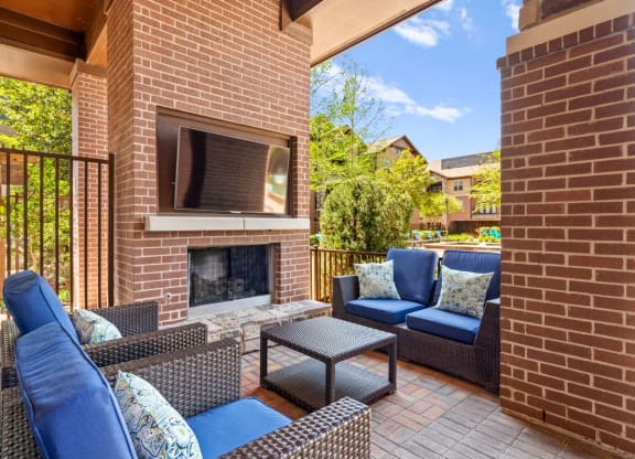 a patio with a brick fireplace and furniture