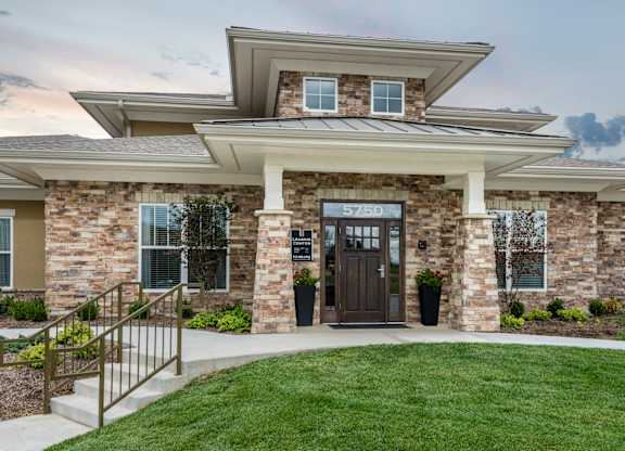 A modern house with a stone facade and a wooden door. at Residences at Prairiefire Apartment Homes, Overland Park