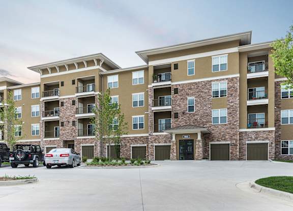 A large apartment complex with a parking lot in front. at Residences at Prairiefire Apartment Homes, Overland Park, KS