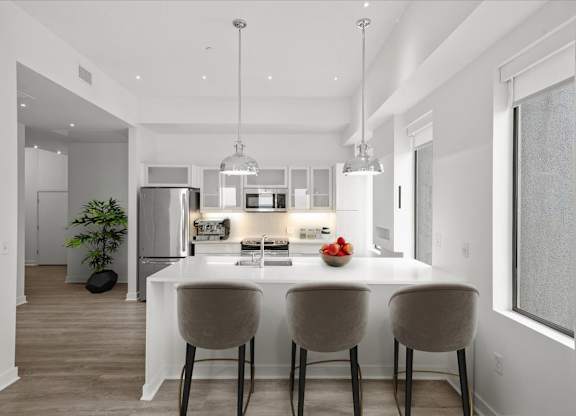A modern kitchen with a dining table and chairs.