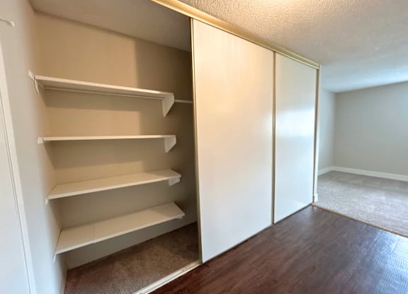 Classic Studio - A white pantry with open doors and shelves.