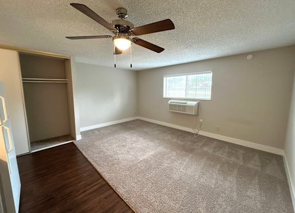 Classic Studio - Living Room with a ceiling fan and a window with an air conditioner unit.