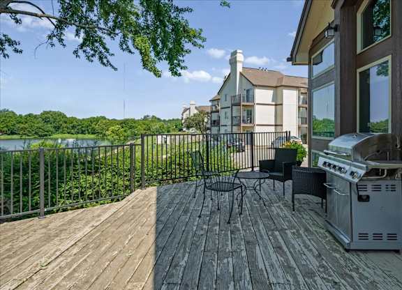 Clubhouse deck overlooking the lake with patio seating, grilling station, and scenic views.