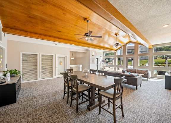 Open clubhouse area with dining seating, natural light, and views of outdoor amenities.