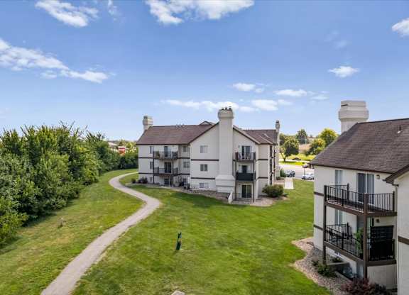 Apartment homes surrounded by open green space and a winding community path.