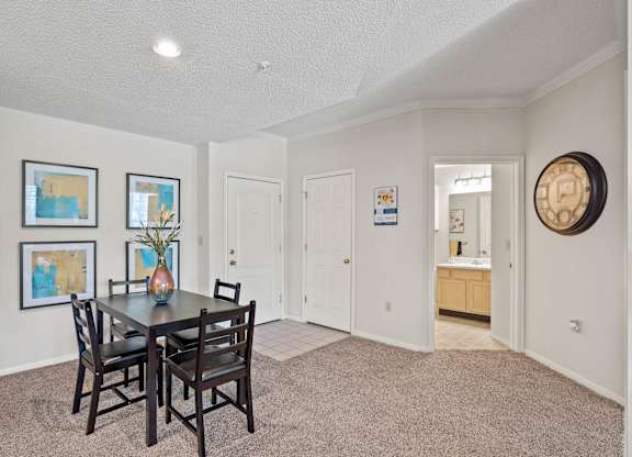 A dining room with an entryway to the bathroom.