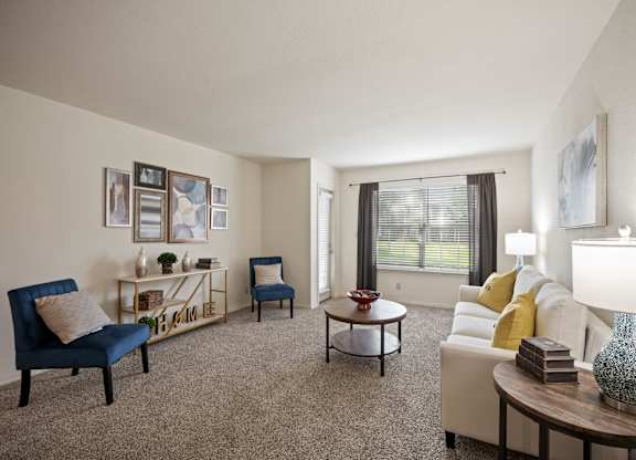 A living room with a blue chair and a white couch.