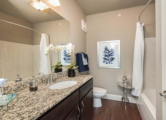 A bathroom with a sink, toilet, and a shower. at Residences at Prairiefire Apartment Homes, Overland Park, Kansas