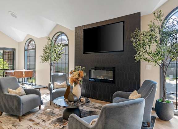 A living room with grey chairs and a black television.