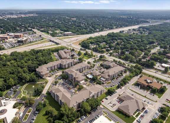 Drone view of The Claremont Apartments highlighting the property layout, surrounding businesses, nearby roadways, and convenient Overland Park location.