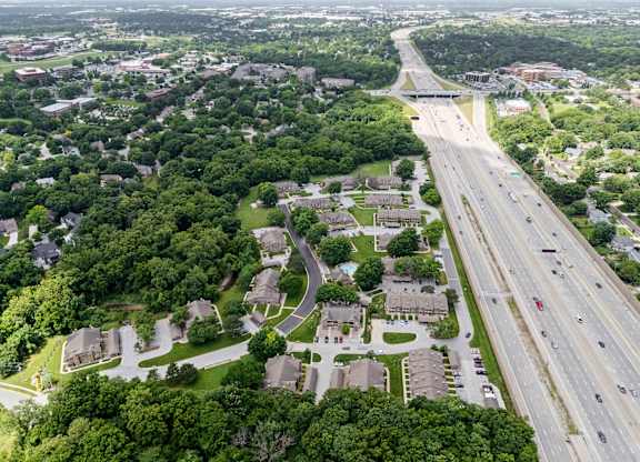 A highway runs through a residential area with houses on both sides.
