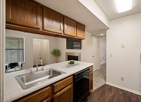A kitchen with wooden cabinets and a black refrigerator.