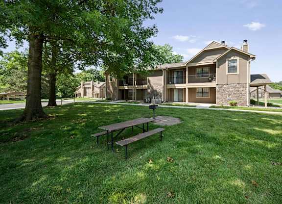 A house with a brown roof and a green lawn.