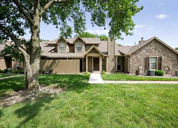A house with a brown roof and a stone wall.