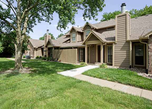 A row of houses with a tree in front of the first one.