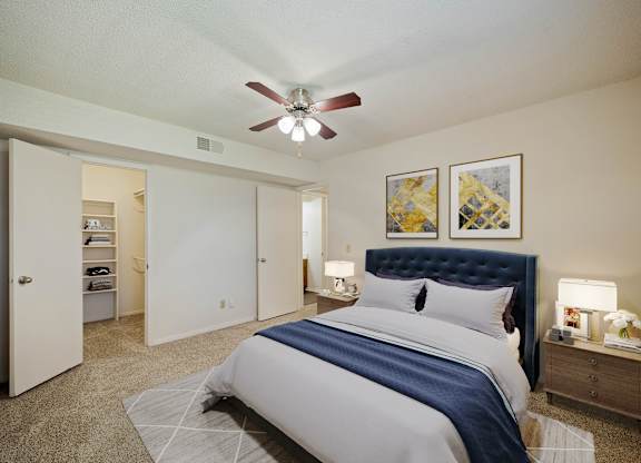 A bedroom with a large bed and a ceiling fan.