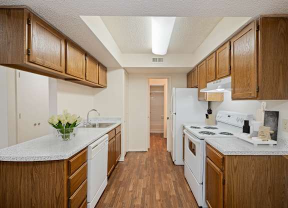 A kitchen with wooden cabinets and white appliances.
