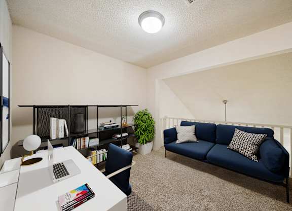 A blue couch sits in a living room with a white table and a plant.