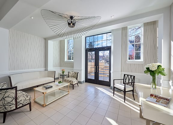 a living room with a white couch and chairs and a large window