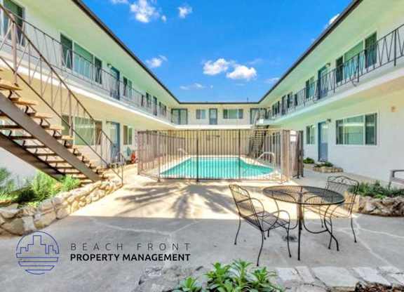 a courtyard with a pool and chairs and a table