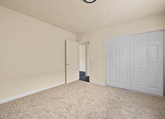 A room with a white door and carpeted floor.