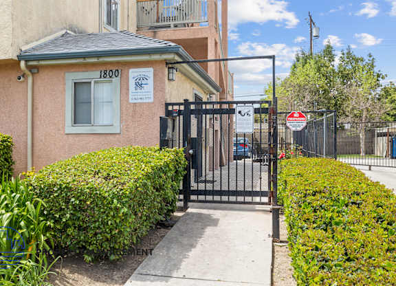 A building with the number 1800 on it is surrounded by a black gate.