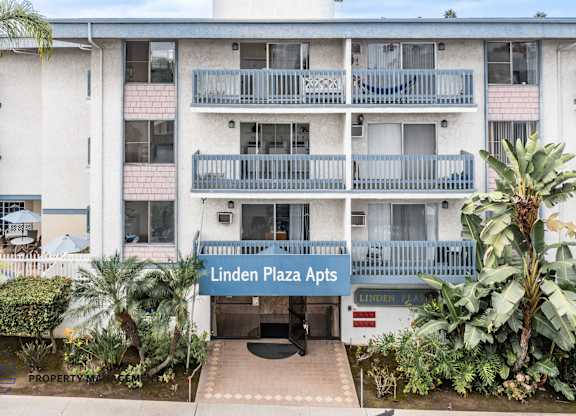 Linden Plaza Apts is a white apartment complex with a blue sign in front.