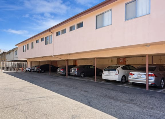 A parking lot with cars parked in front of a building.
