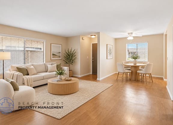 A living room with a couch, a coffee table, a dining table, and chairs.