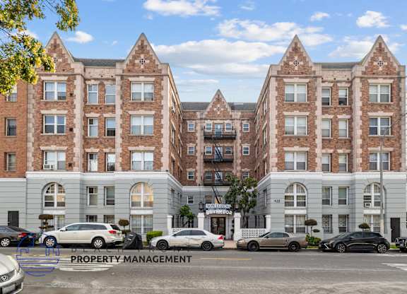 A large brick building with a parking lot in front of it.