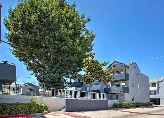 A large grey building with a tree in front of it.